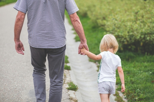 grandparent and child holding hands and walking