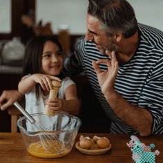 Father and Daughter happily cooking together