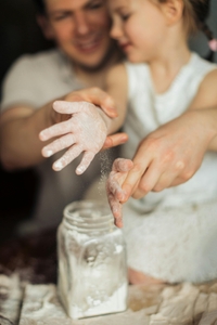 Father and Daughter cooking with flour. Clamping hands together after dusting them with flour. 