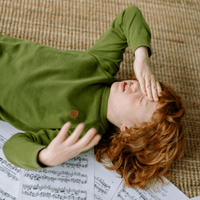 Child on the floor with hand on head