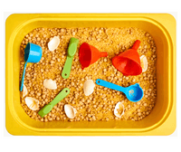 Container filled with chickpeas and ceral, with shells, spoons and funnels ontop