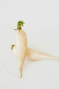 Two daikon radish, one propped ontop of the other at a right angle