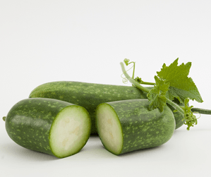 One full winter melon behind a winter melon that has been cut inf half 